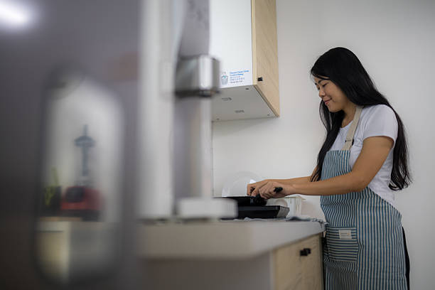 istock Happy Woman Cooking Breakfast in Her Kitchen 2223102970