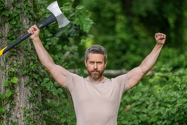 Mature adult man chopping wood in the yard