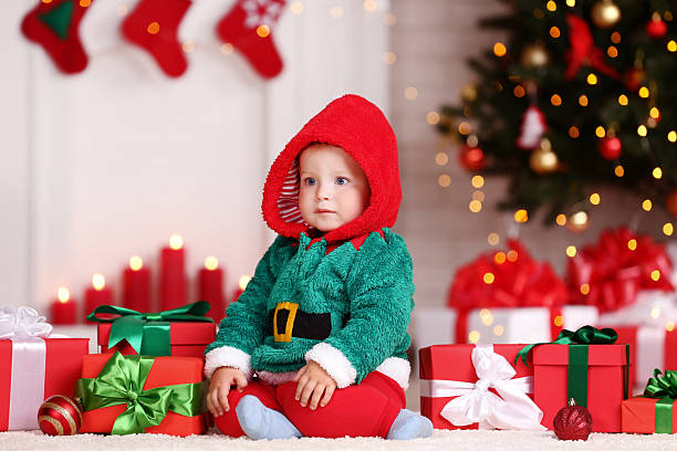 A sweet baby sits comfortably on the sofa, captivated by the festive atmosphere.