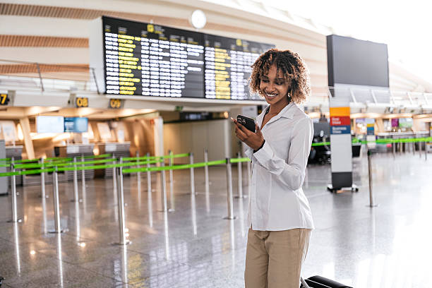 istock Young black woman using smartphone in airport while traveling 2223106650