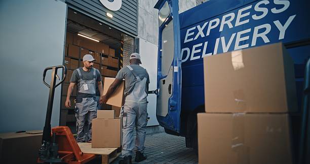 istock Multiethnic Workers Loading Cardboard Boxes from Pallet Truck in Truck for Shipment 2223106870