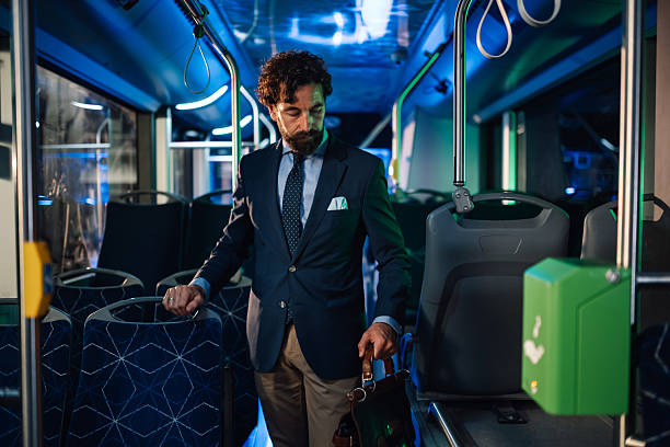istock Businessman standing on a bus at night holding briefcase 2223114268