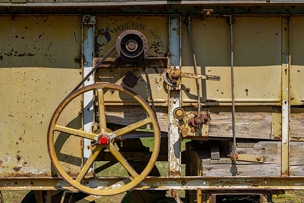 istock old threshing machine featuring a large drive pulley, rusty transmission elements, and faded technical markings on a weathered metal surface. 2223114292