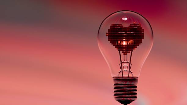 istock Light bulb with pixelated heart shaped filament under radial striped background 2223114518