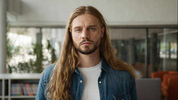 Caucasian pensive student guy man male thinking thoughtful look away serious face expression looking at camera in college university portrait problem trouble stress thoughtful headshot study education