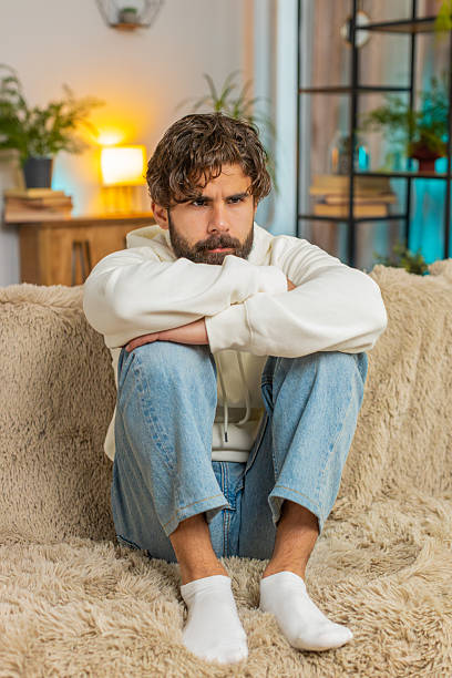 istock Sad frustrated young Indian man sitting at home looks pensive thinks over lonely life problems 2223120704