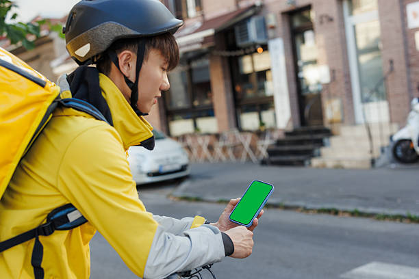 istock Delivery man checking mobile phone outdoors during a route in the city 2223121454