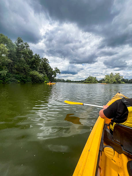 istock Kayaker paddling on calm lake under dramatic cloudy sky 2223122269