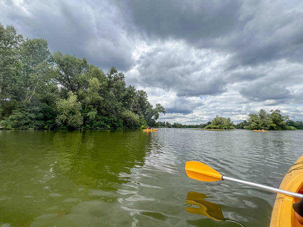 istock Kayaking on green river under cloudy sky with lush vegetation 2223122303