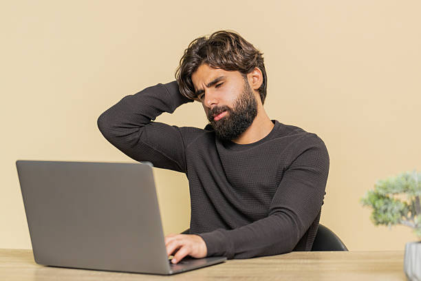 istock Young man using laptop at table loses becoming surprised sudden lottery results on beige background 2223123258
