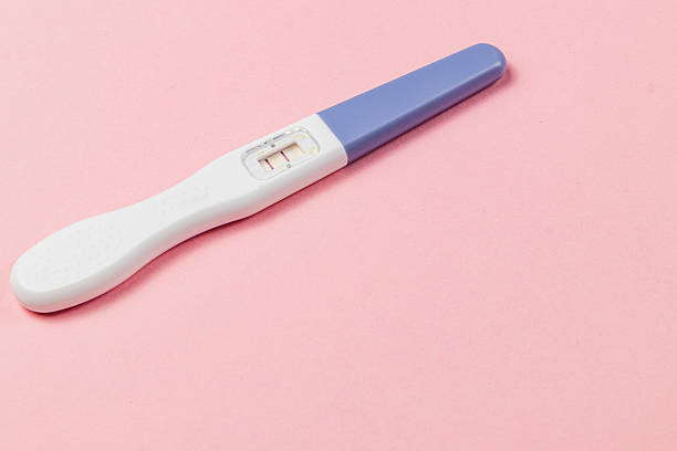 istock Pregnancy test showing two lines on a pink background 2223126785