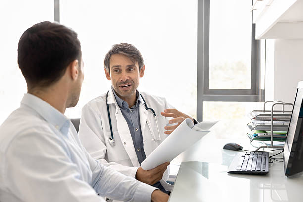 istock Middle aged Hispanic doctor man talking to patient in office 2223128465