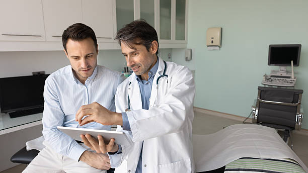 istock Focused middle aged Latin doctor man showing examination reports 2223128961