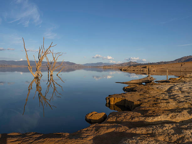 istock Late afternoon sun on reflection lake and red dirt 2223130154