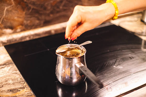 istock Woman adding salt to the brewing coffee on a stove 2223133253