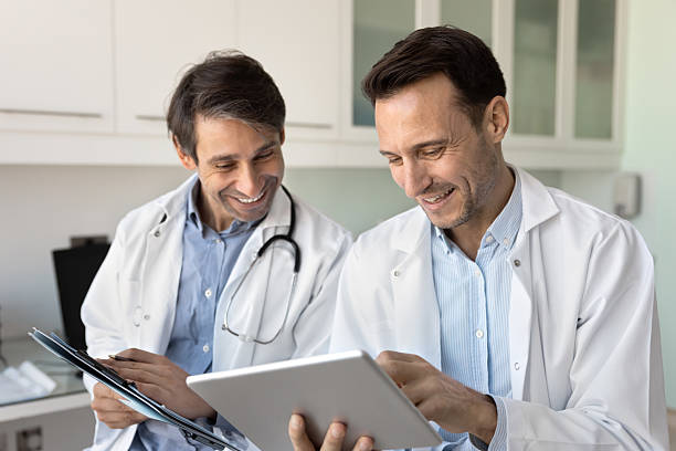 istock Two positive male docs working on medical reports together 2223133866