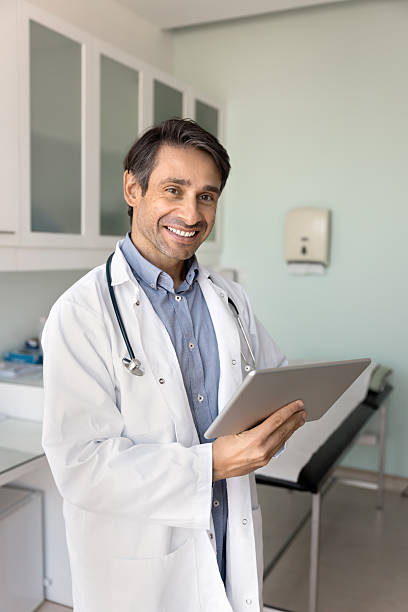 istock Cheerful Hispanic male doctor analyzing electronic medical reports on tablet 2223141784