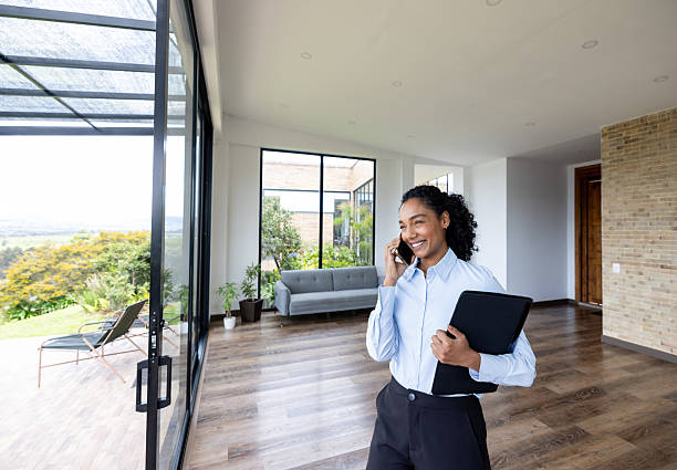 Happy real estate agent taking on the phone while showing a house