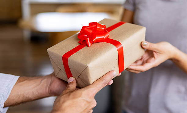 Close-up on a person giving a gift to another one