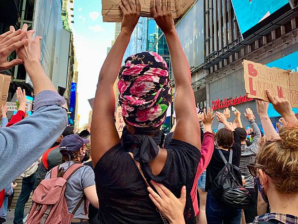 New York, New York, USA- May 31, 2020:  A woman holds up a sign in protest as her friend places her hand on her back in a show of support.