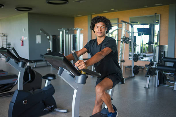 Young man in gym exercising on bike