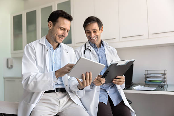 istock Two positive medical colleagues discussing electronic report 2223145719