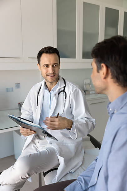 istock Positive general practitioner man talking to patient on appointment 2223147671