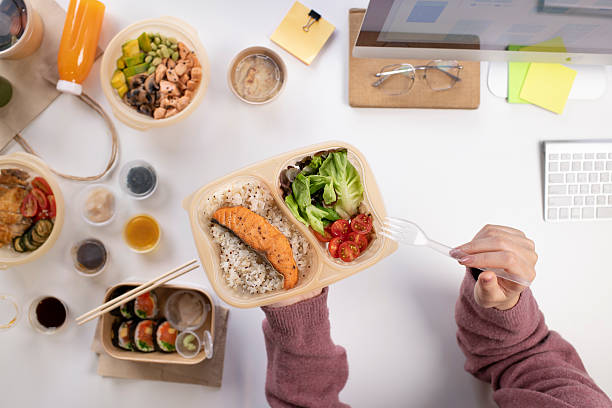istock Asian woman eating healthy meal while working, Top view 2223148223