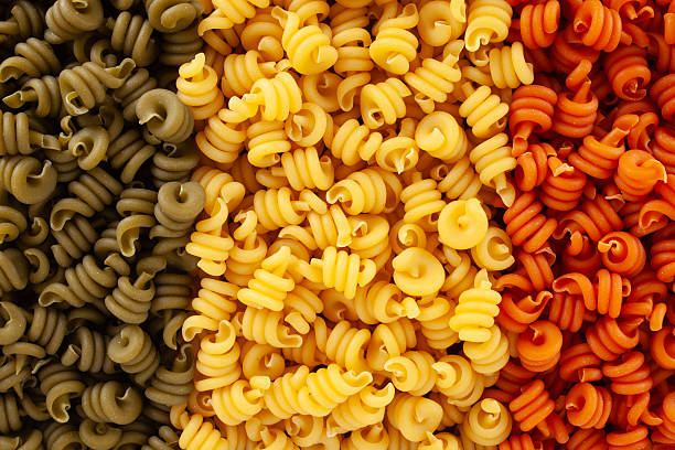 Directly above view of arrangement of raw trottole pasta of three different colors
