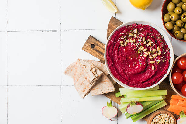 istock Beetroot hummus in a bowl on a board with fresh vegetables, celery, carrots, pita. Copy space 2223151648