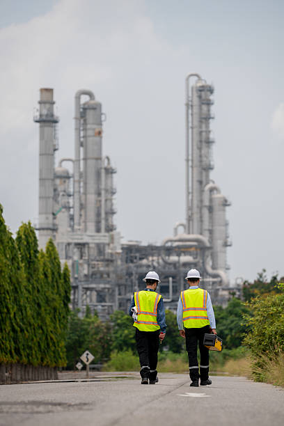 istock Engineers wear safety gear inspecting or document related to plants environment features large industrial chimneys related energy industrial work and environmental monitor carbon credit concept. 2223153791