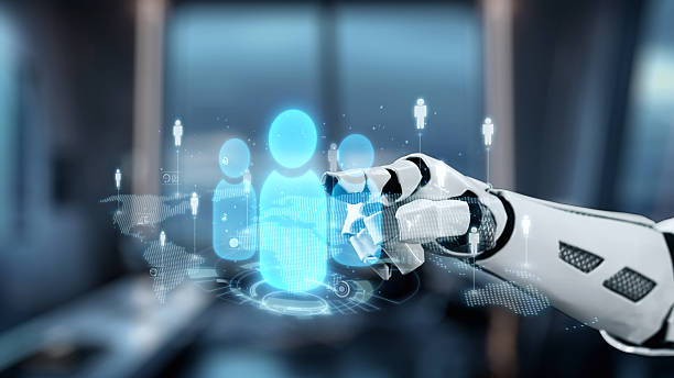 istock Futuristic Robot Hand Interacting with Holographic Human Figures in Modern Office Environment with Soft Focus Background. Auvana 2223156021