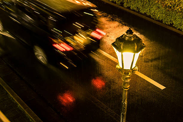 Road lit by street lights on a rainy night