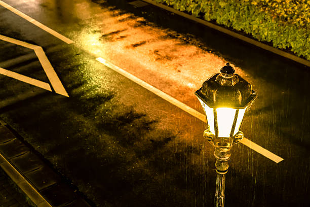 Road lit by street lights on a rainy night