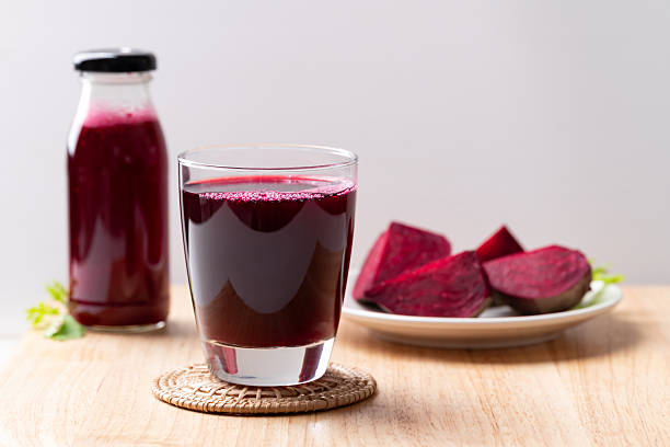 Fresh beetroot juice in glass and bottle on wooden board, Healthy drink