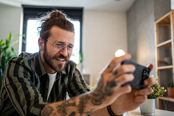 istock Young man playing videogames on mobile phone at home 2223158610