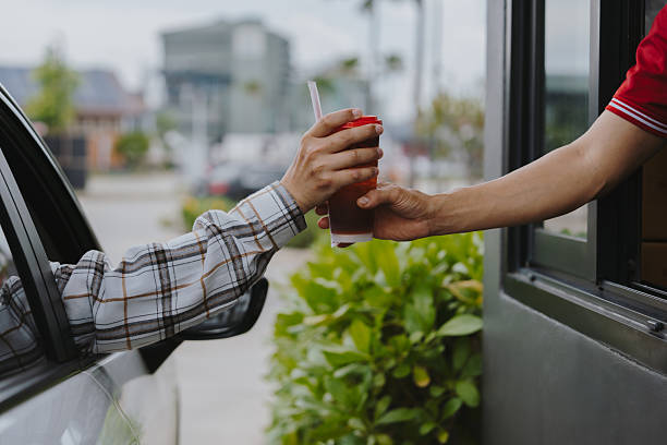 istock Customers receive coffee cups from drive-thru counter staff during rush hour. 2223163158