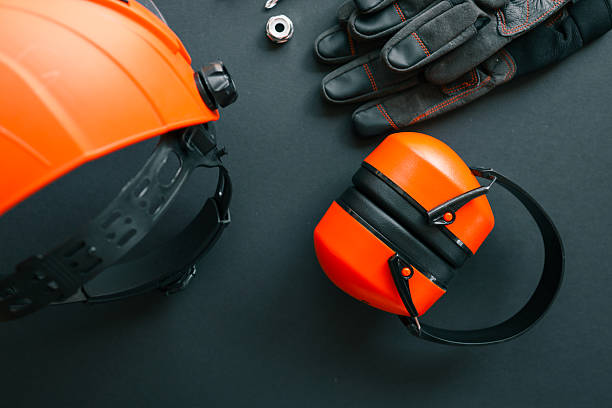 istock Safety face shield, earmuffs, work gloves, screwdriver, wrench and nut arranged on dark background. Set of protective equipment and tools for maintenance of garden brush cutter 2223167978