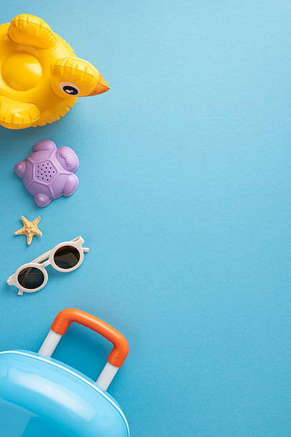 istock Vibrant vertical summer-themed image featuring children's travel items and beach essentials on blue background 2223168072