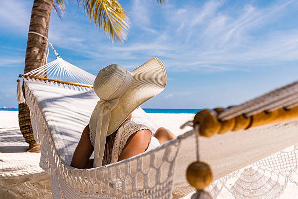istock Relaxed woman with a hat in hammock on the beach. 2223168297