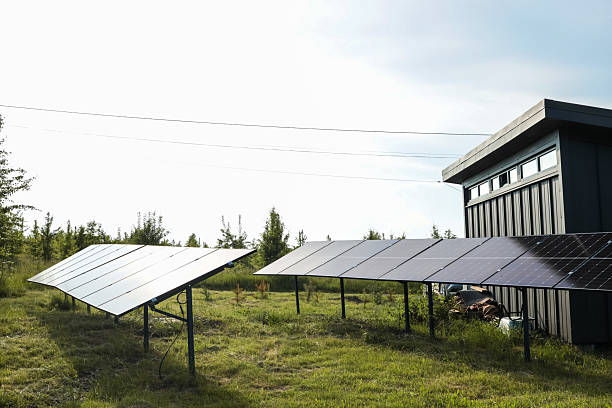 istock Solar panel installations beside a modern utility building in a green field, generating renewable energy on a sunny day 2223171585