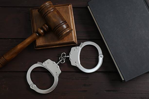 istock Handcuffs, judge's gavel and book on wooden table, flat lay 2223172086