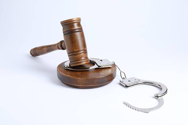 istock Handcuffs and judge's gavel isolated on white 2223172096