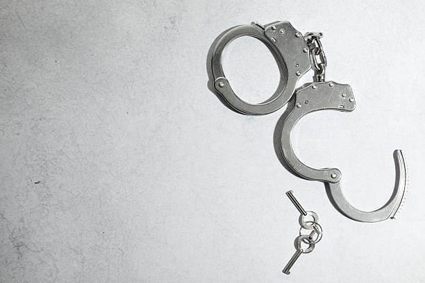 istock Metal chain handcuffs and keys on light grey table, top view. Space for text 2223174642