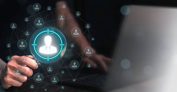 istock Human resources professional holding magnifying glass with people icon. Targeting or selecting suitable candidates in HR and recruitment. Human resources or HR concept. 2223177460