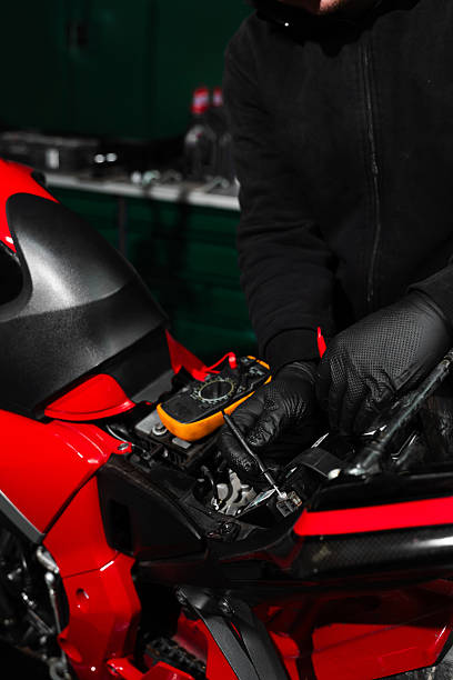 istock Digital multimeter reads motorcycle battery voltage during inspection. Mechanic testing battery with multimeter. Motorcycle battery is tested using digital multimeter to check voltage and health. 2223184216