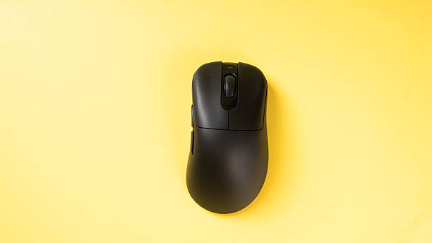 istock A black ergonomic wireless mouse placed on a bright yellow background, showcasing a clean, modern workspace accessory ideal for tech setups or office-themed visuals 2223189085