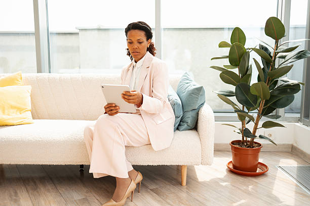 istock Businesswoman reading on a tablet in a modern office lounge 2223190681