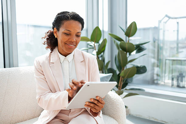 istock Professional woman using tablet in modern office interior with green plants 2223190682