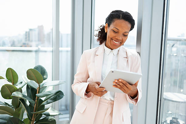 istock Smiling professional woman using tablet indoors by a large window 2223190690